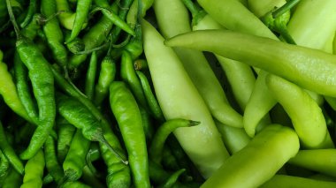İki yeşil biber tipli kırışıklıkların yakın çekimi ve aşçılık veya tarımsal temalar için gösterişli doku, renk ve şekil kontrastı.