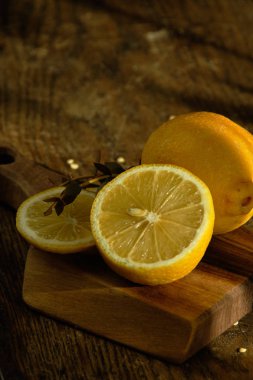 Dilimlenmiş limon ve okaliptüs ahşap bir tahta üzerinde yalan.