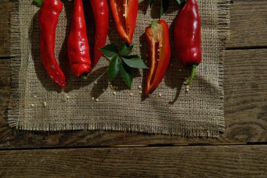 Koyu ahşap bir masada çuval üzerinde kırmızı biber