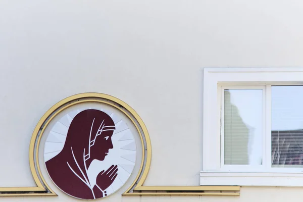 Image of a praying woman on the facade of the house