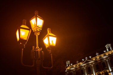 Gece şehrinin siyah arka planında bir fener. Yakın plan.