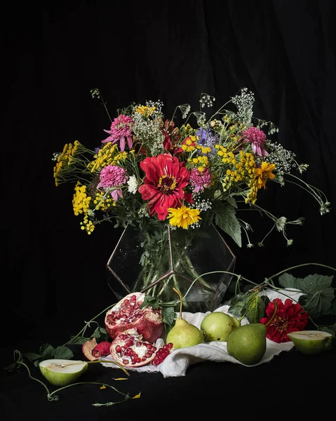 Bouquet of flowers and fruits on a black background.