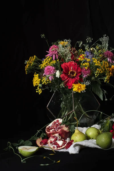 Buquê de flores em um fundo preto, ao lado da fruta — Fotografia de Stock