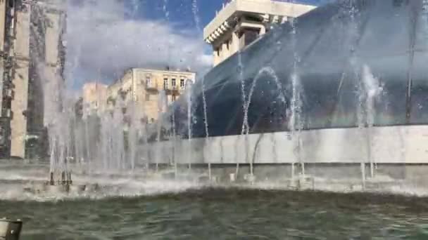 Kiew, Ukraine, 22. Juli 2020 Brunnen auf dem zentralen Platz der Stadt - dem Unabhängigkeitsplatz. Häuser und blauer Himmel sind hinter den Springbrunnen sichtbar. — Stockvideo