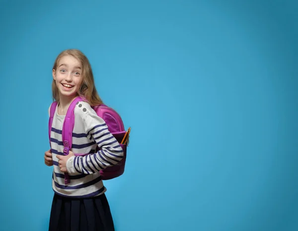 Mavi arka planda, okul çantalı, neşeli, küçük beyaz bir kız. Okul eğitimi kavramı, kopyalama alanı.. — Stok fotoğraf