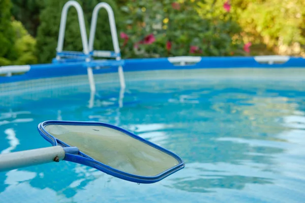 Una red para la piscina en el fondo de agua azul de la piscina marco. Productos y accesorios para el mantenimiento de piscinas. — Foto de Stock