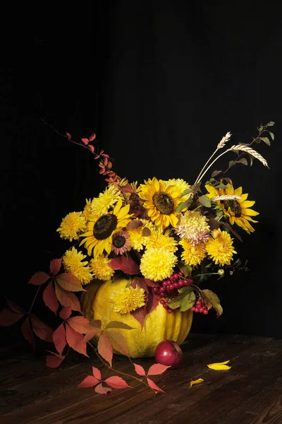 Bloemenarrangement met zonnebloemen in een pompoen op een zwarte achtergrond. Thanksgiving en kopieer ruimte concept — Stockfoto