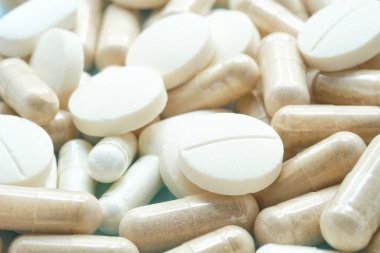 Makro beyaz tablet ve takviye kapsülleri bir arada. Bulanık ve seçici odaklanma 