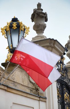 Varşova, Polonya, 14 Eylül 2025. Varşova 'daki Potocki Sarayı cephesinde dalgalanan Polonya bayrağı zengin dekore edilmiş bir fener ve klasik mimari tarafından çerçevelendi..