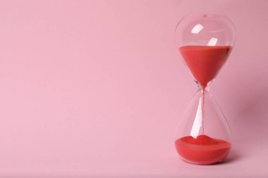 Pembe arka planda kum saati