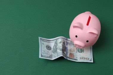 Domuz kumbarası, yeşil arka planda dolar.