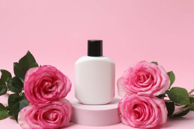 Pembe güller, pembe arka planda kozmetik kavanozlar.