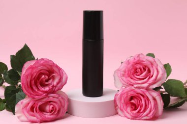 Pembe güller, pembe arka planda kozmetik kavanozlar.