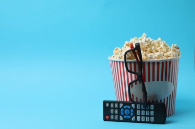 Klasik kırmızı ve beyaz çizgili kutu. Lezzetli, yumuşak patlamış mısır dolu. Mavi arka planda 3 boyutlu gözlük..