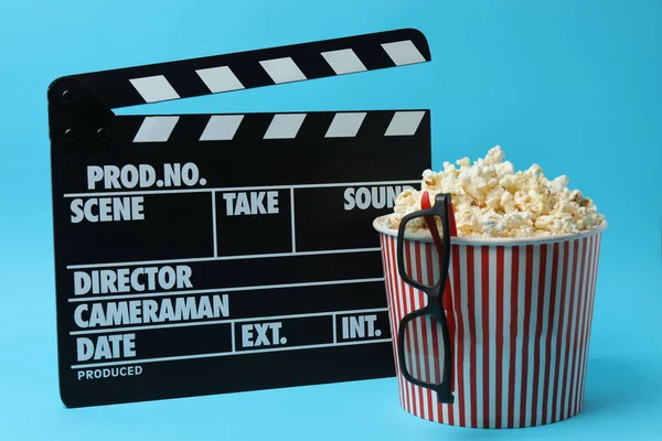 Klasik kırmızı ve beyaz çizgili kutu. Lezzetli, yumuşak patlamış mısır dolu. Mavi arka planda 3 boyutlu gözlük..