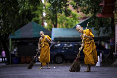 Bangkok, Tayland Nisan 21: İki yaz acemiler birbirlerine Nisan'da tapınak bahçesinde süpürmek için Krommaprawd süpürge kullanmak yardımcı oluyor 21, 2019 Bangkok, Tayland.