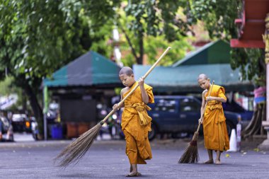 Bangkok, Tayland Nisan 21: İki yaz acemiler birbirlerine Nisan'da tapınak bahçesinde süpürmek için Krommaprawd süpürge kullanmak yardımcı oluyor 21, 2019 Bangkok, Tayland.