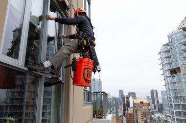 Downtown Vancouver, British Columbia, Kanada - 17 Mayıs 2018: ip erişim yüksek artış pencere temizleyici yüksek bir binanın üzerinde çalışıyor.