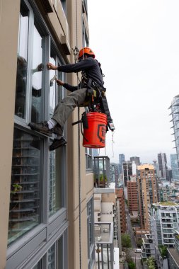 Downtown Vancouver, British Columbia, Kanada - 17 Mayıs 2018: ip erişim yüksek artış pencere temizleyici yüksek bir binanın üzerinde çalışıyor.