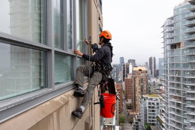 Downtown Vancouver, British Columbia, Kanada - 17 Mayıs 2018: ip erişim yüksek artış pencere temizleyici yüksek bir binanın üzerinde çalışıyor.