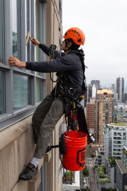Downtown Vancouver, British Columbia, Kanada - 17 Mayıs 2018: ip erişim yüksek artış pencere temizleyici yüksek bir binanın üzerinde çalışıyor.