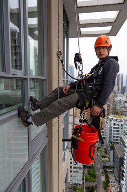 Downtown Vancouver, British Columbia, Kanada - 17 Mayıs 2018: ip erişim yüksek artış pencere temizleyici yüksek bir binanın üzerinde çalışıyor.