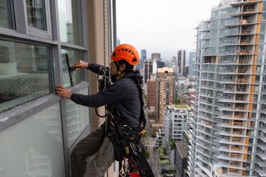 Downtown Vancouver, British Columbia, Kanada - 17 Mayıs 2018: ip erişim yüksek artış pencere temizleyici yüksek bir binanın üzerinde çalışıyor.