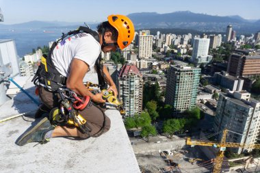 Downtown Vancouver, British Columbia, Kanada - 15 Mayıs 2018: ip erişim yüksek artış pencere temizleyici yüksek bir binanın üzerinde çalışıyor.