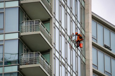 Richmond, büyük Vancouver, British Columbia, Kanada - 8 Mayıs 2018: Yüksek artış pencere temizleyici halatlar üzerinde asılı ve çalışma.