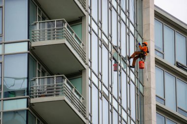 Richmond, büyük Vancouver, British Columbia, Kanada - 8 Mayıs 2018: Yüksek artış pencere temizleyici halatlar üzerinde asılı ve çalışma.