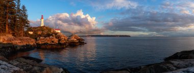 Güzel panoramik bir deniz feneri bir bulutlu gün batımı sırasında kayalık bir kıyısında. Horseshoe Bay, Batı Vancouver, British Columbia, Kanada alınan.