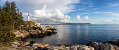 Güzel panoramik bir deniz feneri bulutlu bir akşam sırasında kayalık bir kıyısında. Horseshoe Bay, Batı Vancouver, British Columbia, Kanada alınan.