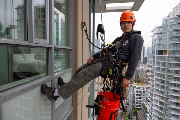 Downtown Vancouver, British Columbia, Kanada - 17 Mayıs 2018: ip erişim yüksek artış pencere temizleyici yüksek bir binanın üzerinde çalışıyor.