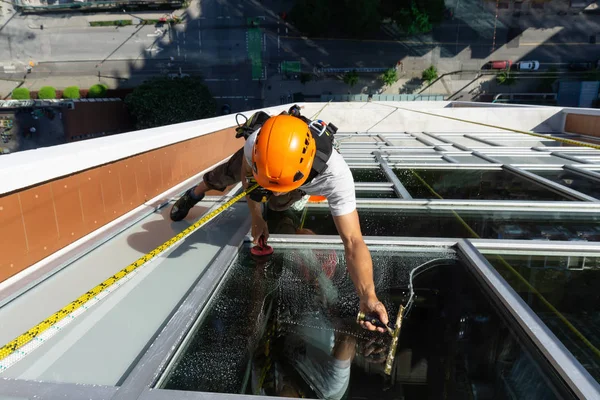 Downtown Vancouver, British Columbia, Kanada - 15 Mayıs 2018: ip erişim yüksek artış pencere temizleyici yüksek bir binanın üzerinde çalışıyor.