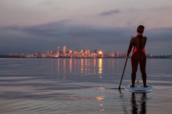 在一个充满活力的日落的背景下 在一个桨板上的冒险女孩是 Paddeling 在海洋与市中心城市 靠近西班牙银行 温哥华 不列颠哥伦比亚省 加拿大 — 图库照片