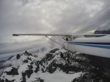 Bulutlu bir gece boyunca güzel Kanada dağ peyzaj üzerinde uçan uçak. Vancouver, British Columbia, Kanada kuzeyindeki alınan.