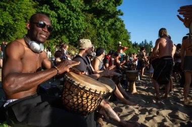 Üçüncü plaj, Downtown Vancouver, British Columbia, Kanada - 22 Mayıs 2018: eğleniyor bir Drum Circle olay sırasında canlı bir günbatımı insanlar.