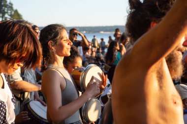 Üçüncü plaj, Downtown Vancouver, British Columbia, Kanada - 22 Mayıs 2018: eğleniyor bir Drum Circle olay sırasında canlı bir günbatımı insanlar.