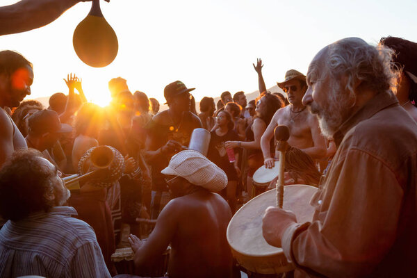 Third Beach, Downtown Vancouver, British Columbia, Canada - May 22, 2018: People having fun at a Drum Circle Event during a vibrant sunset.