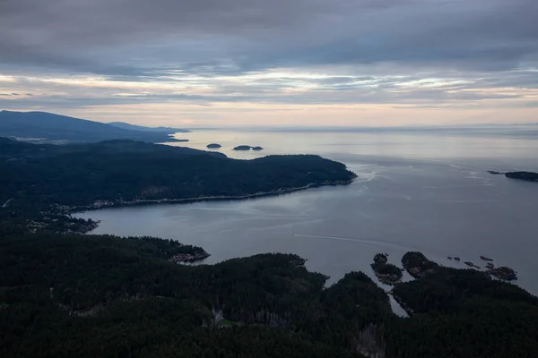 Aerial view of Sunshine Coast during a vibrant cloudy sunset. Located Northwest of Vancouver, British Columbia, Canada.