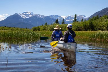 Vermilion göller, Banff, Alberta, Kanada - 19 Haziran 2018: Çift maceracı arkadaşlar Kanada dağlarla çevrili bir gölde Kano.