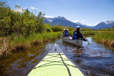 Vermilion göller, Banff, Alberta, Kanada - 19 Haziran 2018: Çift maceracı arkadaşlar Kanada dağlarla çevrili bir gölde Kano.