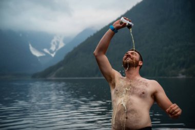 Doğada bir parti sırasında kendini bir kutu biradan dökülen adam. Jones Gölü, doğusunda Vancouver, Bc, Kanada çekilmiş.