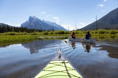 Vermilion göller, Banff, Alberta, Kanada - 19 Haziran 2018: Çift maceracı arkadaşlar Kanada dağlarla çevrili bir gölde Kano.