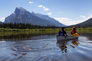 Vermilion göller, Banff, Alberta, Kanada - 19 Haziran 2018: Çift maceracı arkadaşlar Kanada dağlarla çevrili bir gölde Kano.