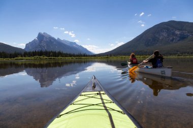 Vermilion göller, Banff, Alberta, Kanada - 19 Haziran 2018: Çift maceracı arkadaşlar Kanada dağlarla çevrili bir gölde Kano.