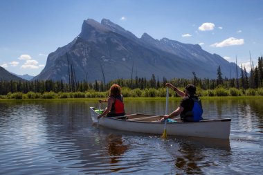 Kaç maceracı arkadaşlar Kanada dağlarla çevrili bir gölde Kano. Alınan Vermilion göllerde, Banff, İngiltere.