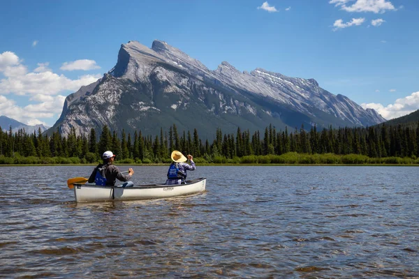Vermilion göller, Banff, Alberta, Kanada - 19 Haziran 2018: Çift maceracı arkadaşlar Kanada dağlarla çevrili bir gölde Kano.