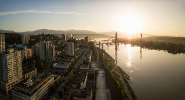 Aerial Panoramic view of Fraser River and Bridges during a vibrant sunrise. Taken in New Westminster, Greater Vancouver, British Columbia, Canada. clipart