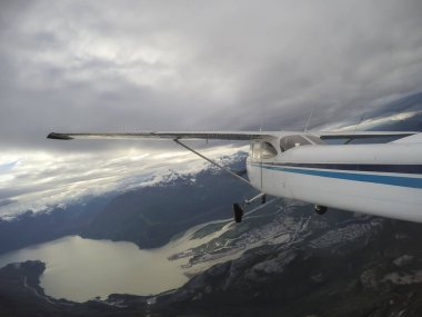 Bulutlu bir gece boyunca güzel Kanada dağ peyzaj üzerinde uçan uçak. Vancouver, British Columbia, Kanada kuzeyindeki alınan.